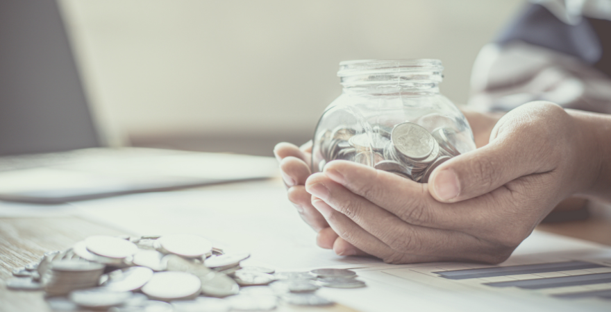 Hands holding jar of coins