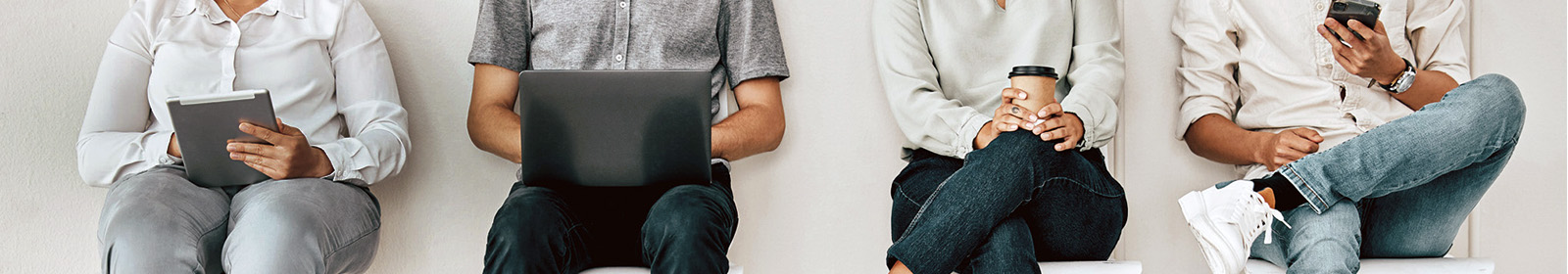 4 people sitting in waiting chairs holding tablet laptop coffee and phone