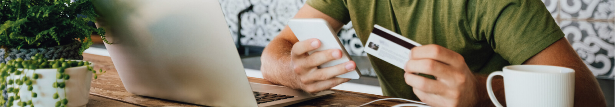 person holding smartphone in one hand and credit card in the other