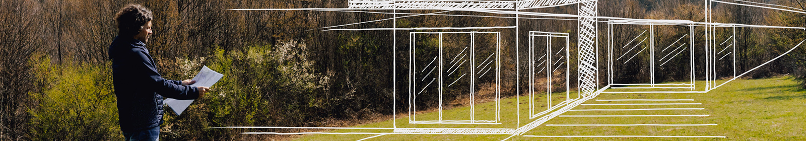 person looking at building plans with vacant land lot in background