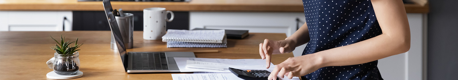 zoomed in image of woman at kitchen table with laptop