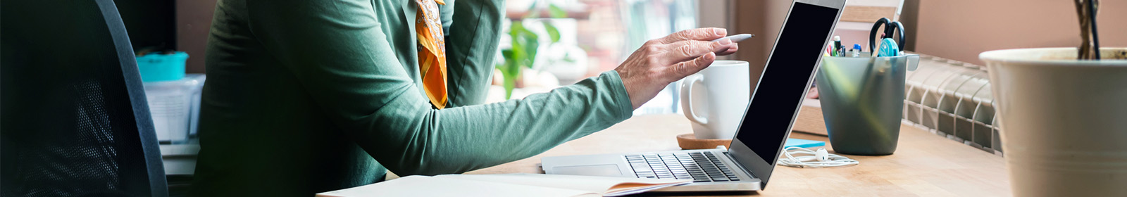 zoomed in image of woman at desk with open laptop